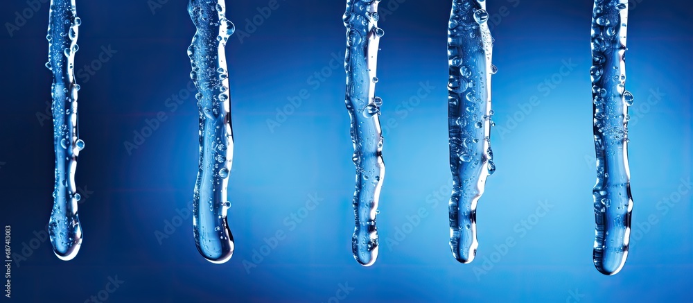 Five blue icicles melting with water droplets. Five blue icicles melting with water droplets.