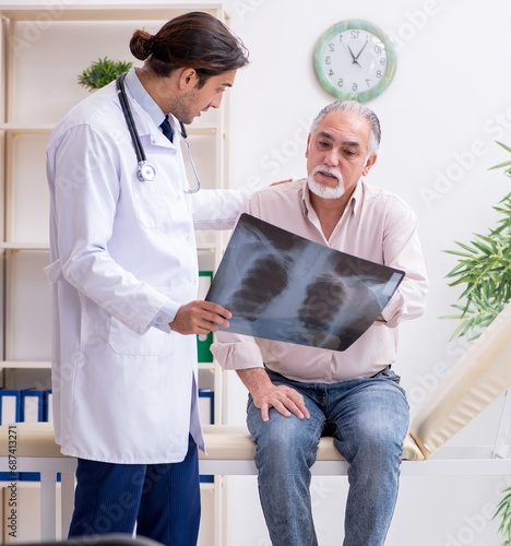 Canvas Print Young male doctor and old patient in antismoking concept