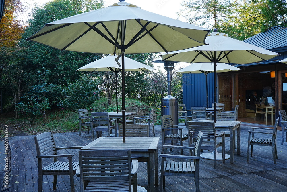 Obraz premium Outdoor Patio Table and Chair under Sunshade Umbrella, Image of Cafe Outside - 屋外 テーブルと椅子