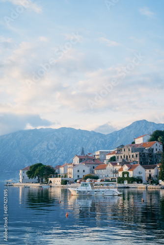 Tourist boat is moored to the coast of Perast against the backdrop of mountains. Montenegro