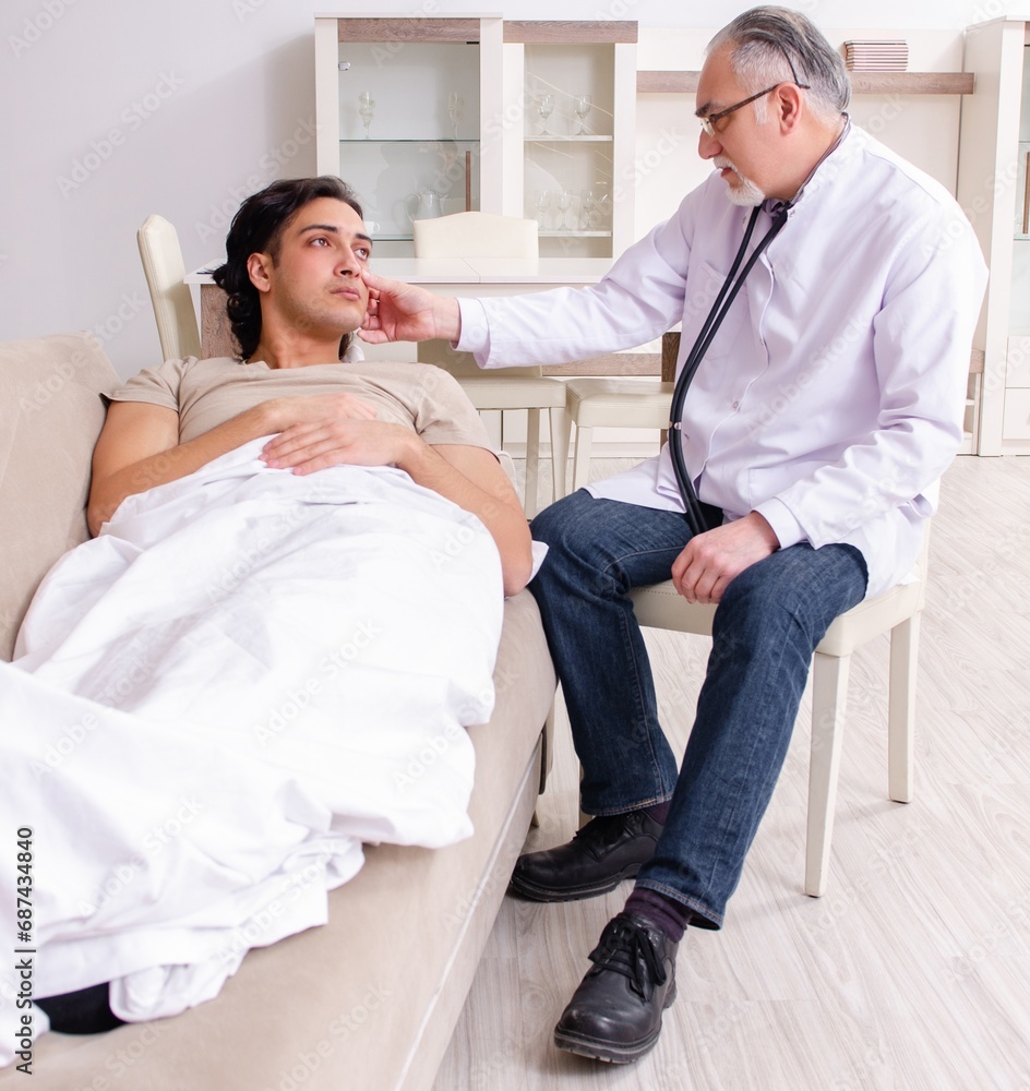 Obraz premium Old male doctor visiting young male patient