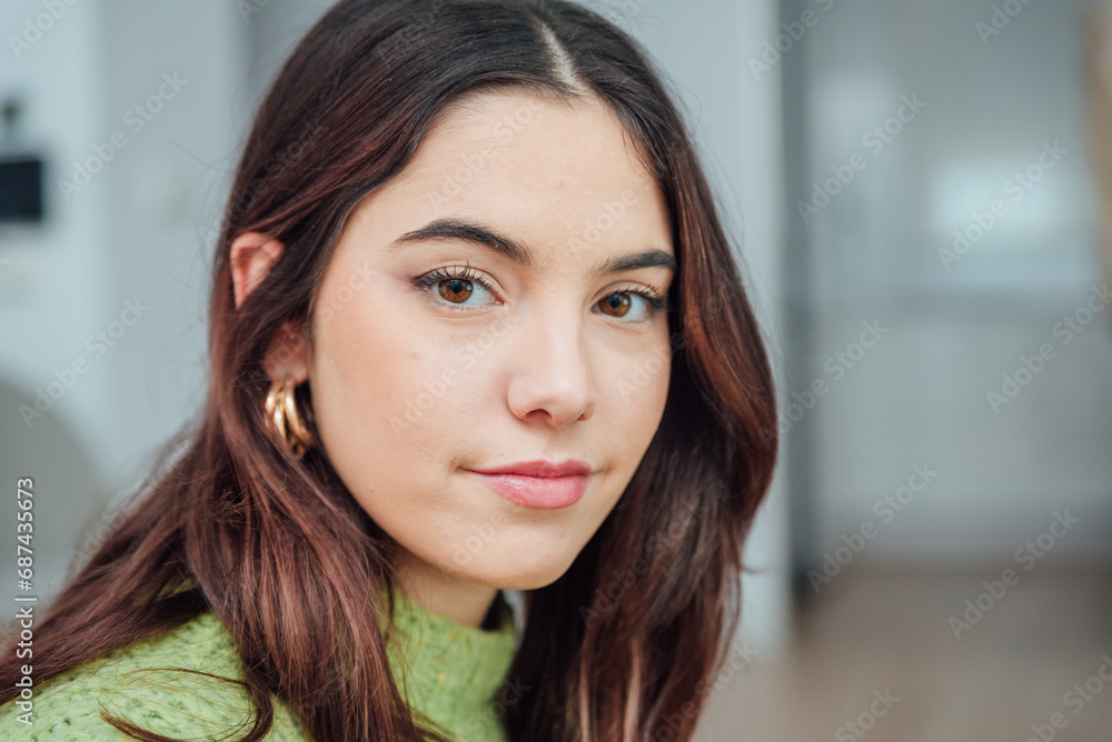 Smiling young ethnic woman with earrings standing in blurred room Smiling young ethnic woman with earrings standing in blurred room