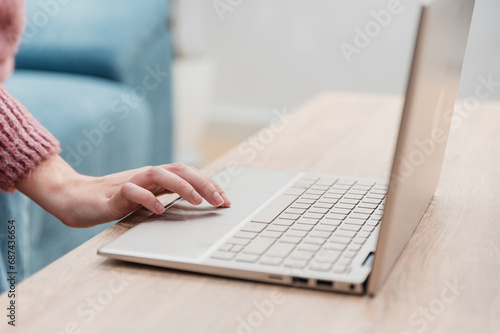 Crop woman working on laptop over table