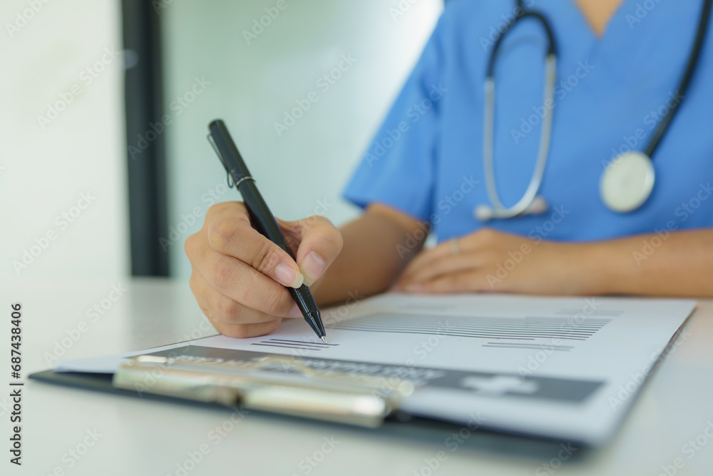 The doctor sitting at a desk and writing a prescription for her patient. The doctor sitting at a desk and writing a prescription for her patient.