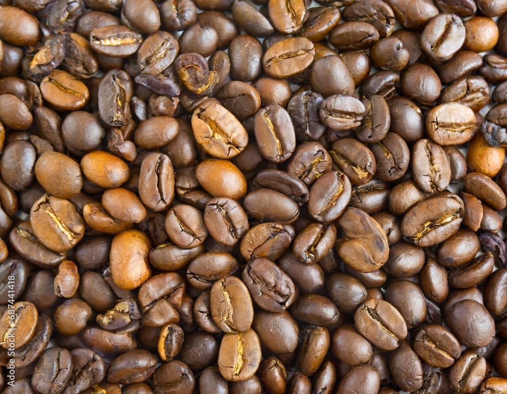 Close up of a bunch of coffee beans background top view; roasted dark brown coffe seeds Close up of a bunch of coffee beans background top view; roasted dark brown coffe seeds