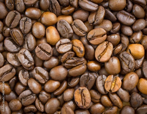 Close up of a bunch of coffee beans background top view  roasted dark brown coffe seeds