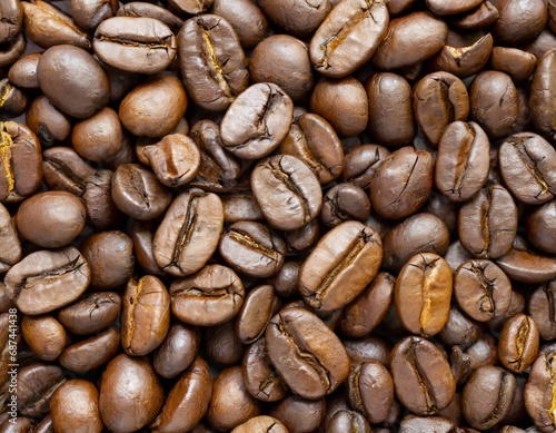 Close up of a bunch of coffee beans background top view  roasted dark brown coffe seeds