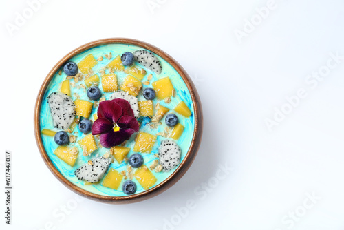 Delicious smoothie bowl with fresh fruits, blueberries, flower and oatmeal on white background, top view. Space for text