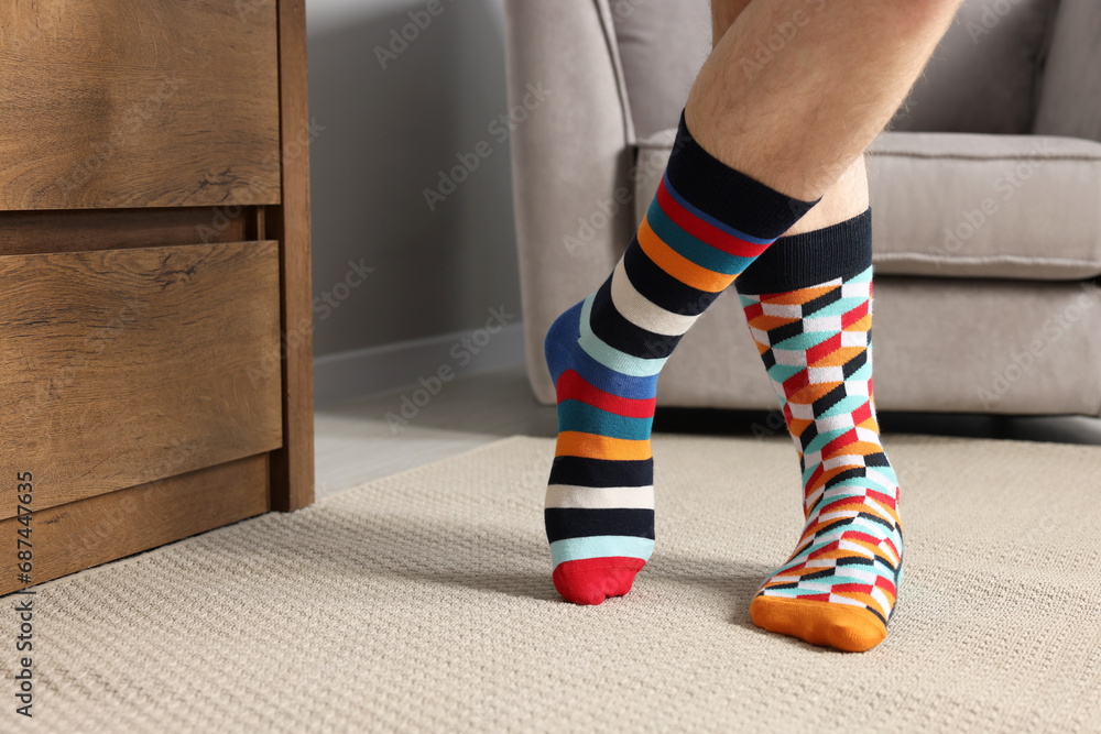 Man in different stylish socks indoors, closeup. Space for text Man in different stylish socks indoors, closeup. Space for text