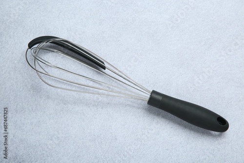 Metal whisk on gray table, top view