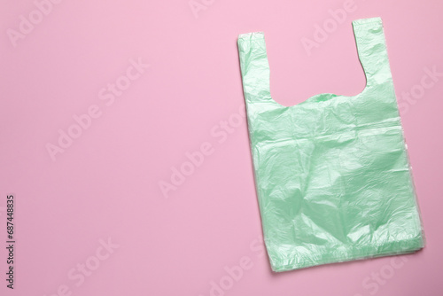 Pack of plastic bags on pink background, top view. Space for text