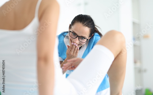 Woman gynecologist in glasses examines patient in clinic office with surprise portrait. Removal of foreign bodies from vagina gynecology concept. photo