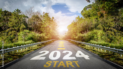 2024 Goals, Plans and Visions concept. Text START 2024 with arrow symbol  written on the road in the middle of asphalt road with at sunset. Business target, planning, challenge, Start of new year. photo