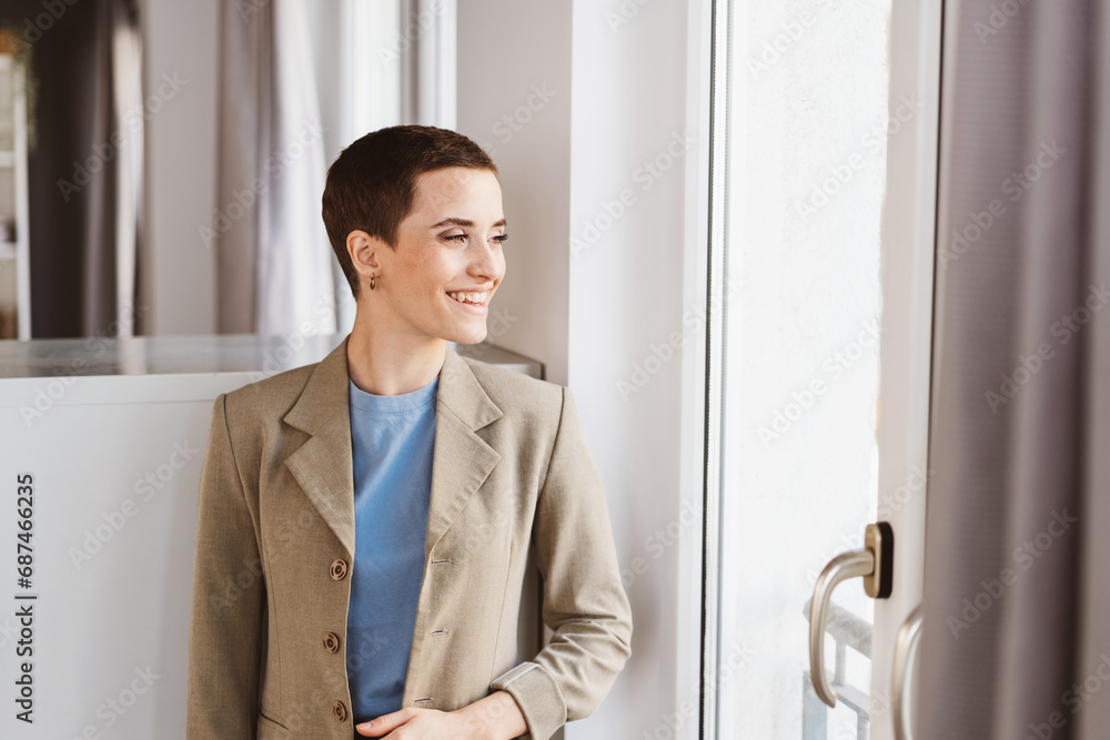 Laughing Young Woman in Jacket, Short Hair, Gazing out the Office Window Laughing Young Woman in Jacket, Short Hair, Gazing out the Office Window