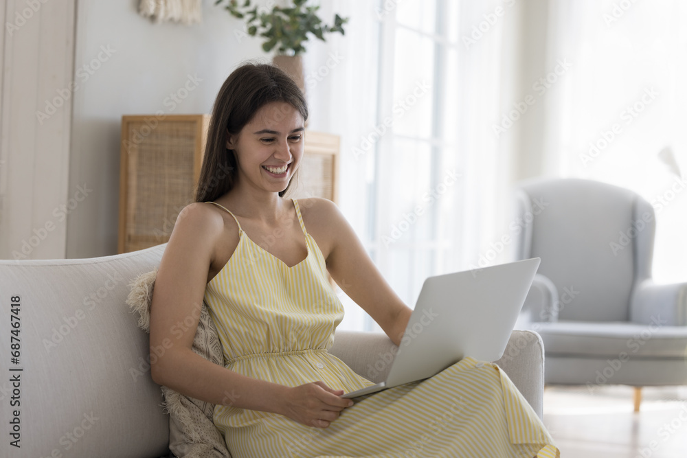 Cheerful woman laugh watch on-line movie using laptop, sit on sofa enjoy pleasant carefree weekend rest on internet, enjoy videocall, share happy news spend untroubled time at home with modern tech Cheerful woman laugh watch on-line movie using laptop, sit on sofa enjoy pleasant carefree weekend rest on internet, enjoy videocall, share happy news spend untroubled time at home with modern tech