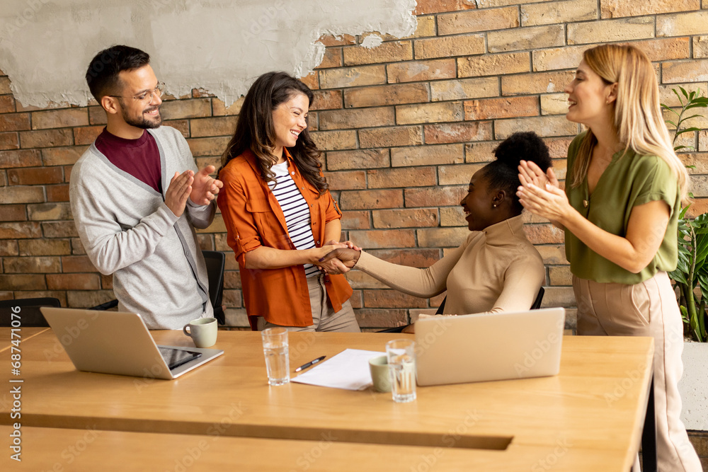 Young multiethnic startup team working by the brick wall in the industrial style office Young multiethnic startup team working by the brick wall in the industrial style office