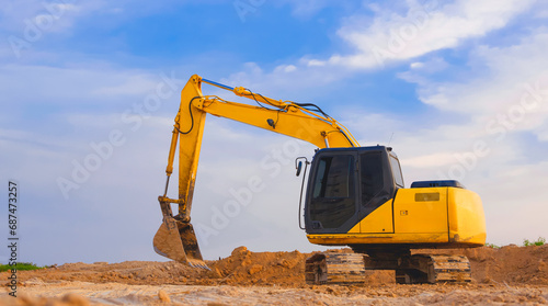 Fotografi Yellow excavator is leveling the ground for construction area of industrial buil