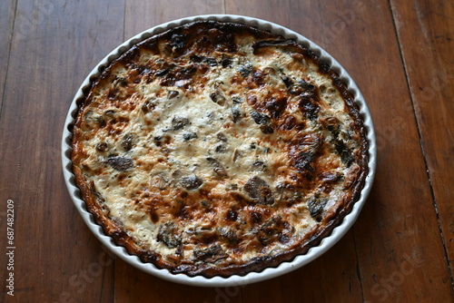 Mushrooms quiche, a French style tart consisting of pastry crust filled with savory custard and pieces of cheese and Champignon mushrooms 