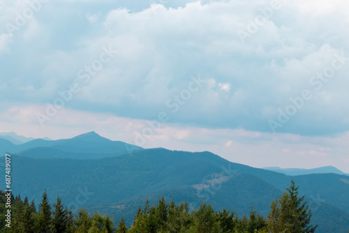 Amazing mountain landscape. Morning panorama of the forest, pine trees and silhouettes of mountains