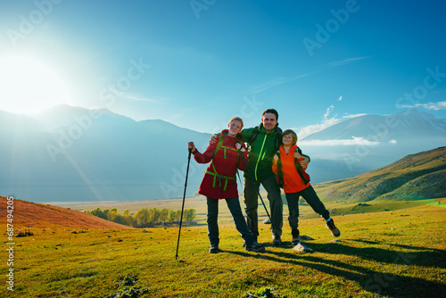 Happy hiking family in the mountains on a sunny day at autumn
