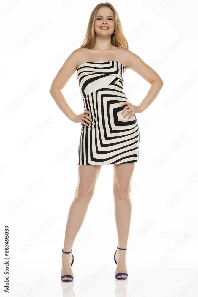 Fototapeta premium Full body front view portrait of elegant lovely blond lady posing isolated on white background in black and white short summer dress