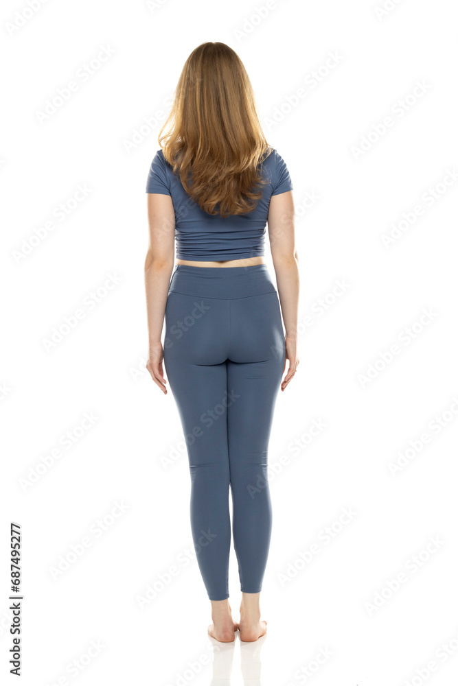 Full body, back view young woman in sportswear posing on white background Full body, back view young woman in sportswear posing on white background