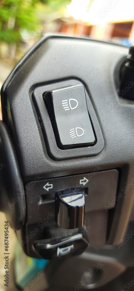 Close-up of view switch light, turn signals, and horn button on left Matic motorcycle handlebar controls