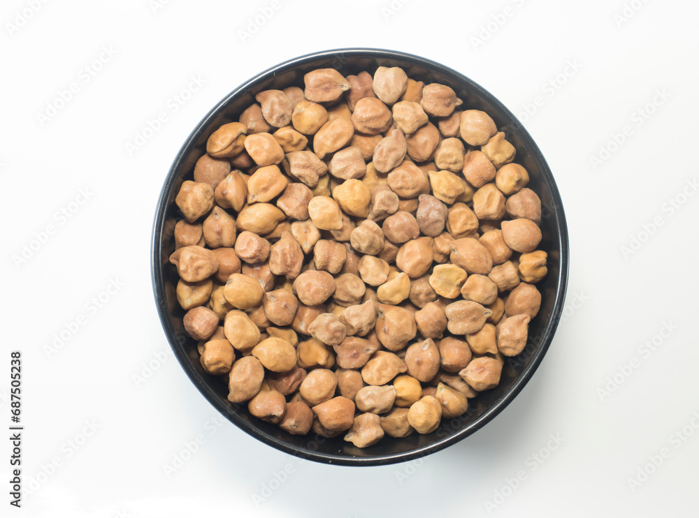 macro Close-up of Organic chana or chickpea (Cicer arietinum) or whole white Bengal gram dal on a ceramic black bowl. Top view macro Close-up of Organic chana or chickpea (Cicer arietinum) or whole white Bengal gram dal on a ceramic black bowl. Top view