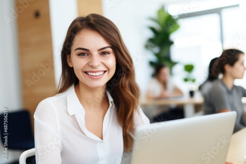 Happy business woman using laptop in office
