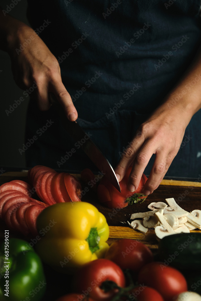 close-up of the cook's hands slicing tomatoes close-up of the cook's hands slicing tomatoes