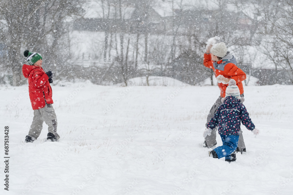 Kids play snowballs. Children have fun outside in the winter during snowfall. Winter entertainment Kids play snowballs. Children have fun outside in the winter during snowfall. Winter entertainment