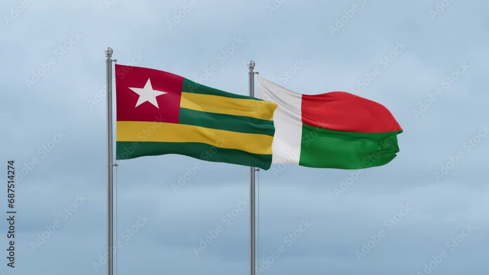 Madagascar flag and Togo flag waving together on cloudy sky, endless seamless loop, two country relations concept Madagascar flag and Togo flag waving together on cloudy sky, endless seamless loop, two country relations concept