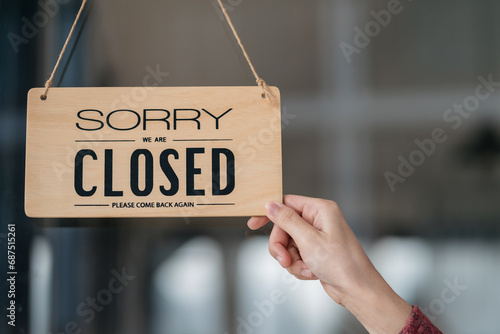 Successful small business owner holding open sign.