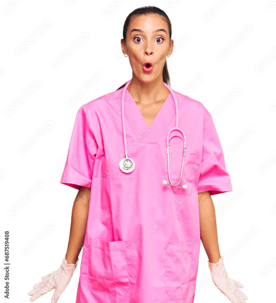 Young hispanic woman wearing doctor uniform and stethoscope scared and amazed with open mouth for surprise, disbelief face Young hispanic woman wearing doctor uniform and stethoscope scared and amazed with open mouth for surprise, disbelief face