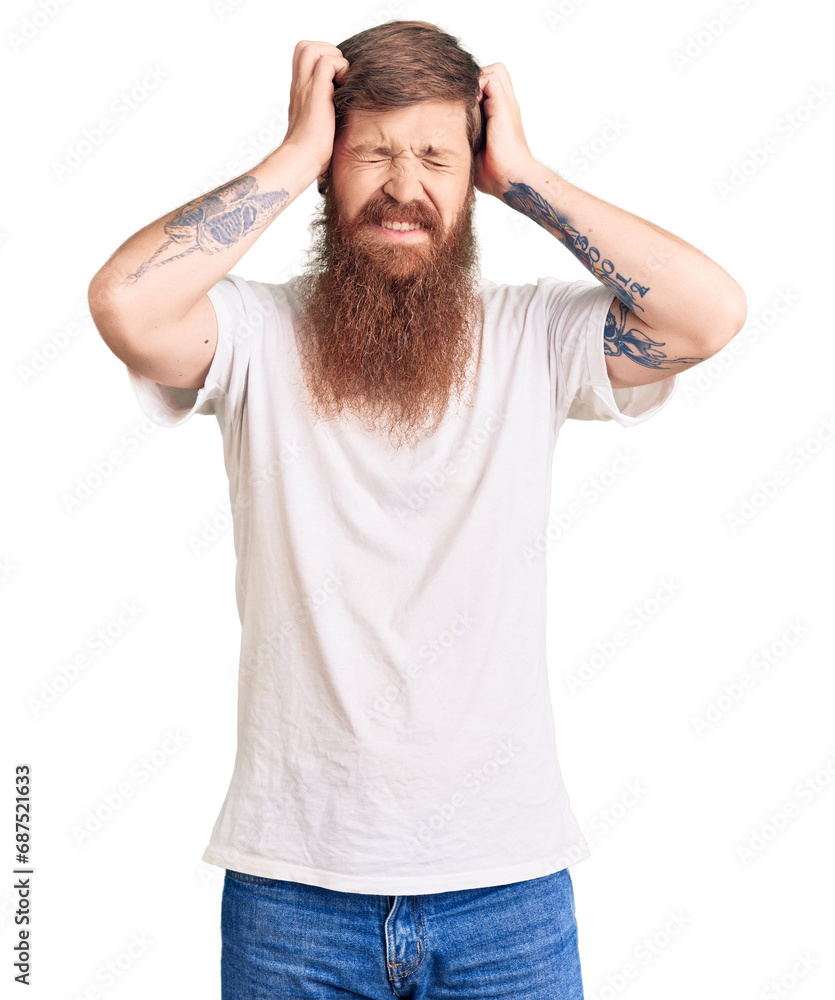 Handsome young red head man with long beard wearing casual white tshirt suffering from headache desperate and stressed because pain and migraine. hands on head. Handsome young red head man with long beard wearing casual white tshirt suffering from headache desperate and stressed because pain and migraine. hands on head.