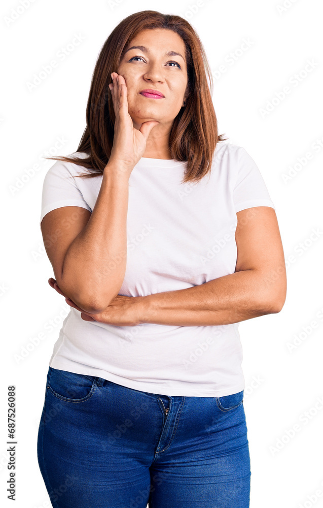 Middle age latin woman wearing casual white tshirt with hand on chin thinking about question, pensive expression. smiling and thoughtful face. doubt concept. Middle age latin woman wearing casual white tshirt with hand on chin thinking about question, pensive expression. smiling and thoughtful face. doubt concept.