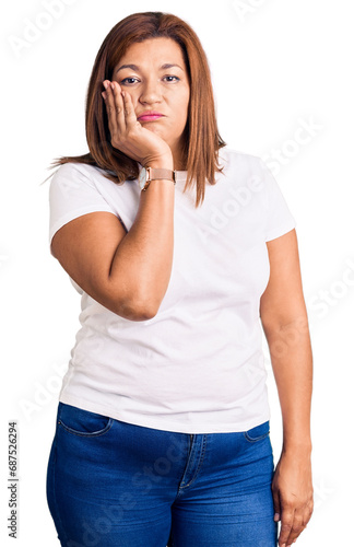 Middle age latin woman wearing casual white tshirt thinking looking tired and bored with depression problems with crossed arms.