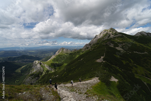 Polish Tatras, people go hiking to Mount Giewont, summer tar sky with clouds.