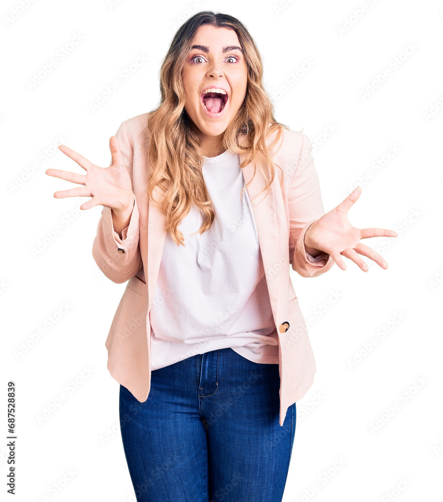 Young caucasian woman wearing business clothes celebrating crazy and amazed for success with arms raised and open eyes screaming excited. winner concept Young caucasian woman wearing business clothes celebrating crazy and amazed for success with arms raised and open eyes screaming excited. winner concept