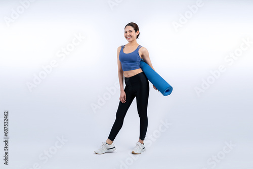 Young attractive asian woman portrait in sportswear with exercising mat. Healthy exercise and workout routine lifestyle concept. Studio shot isolated background. Vigorous