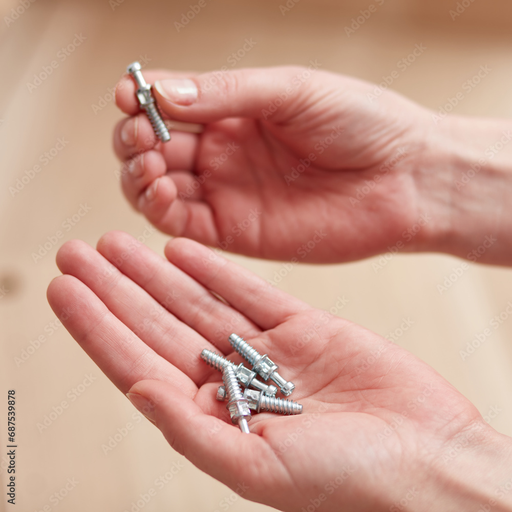 Female hands holding the screws in their hands. Concept for self-contained, easy furniture assembly. Female hands holding the screws in their hands. Concept for self-contained, easy furniture assembly.