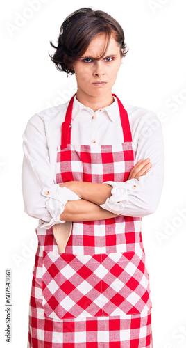 Beautiful young woman with short hair wearing professional cook apron skeptic and nervous, disapproving expression on face with crossed arms. negative person.