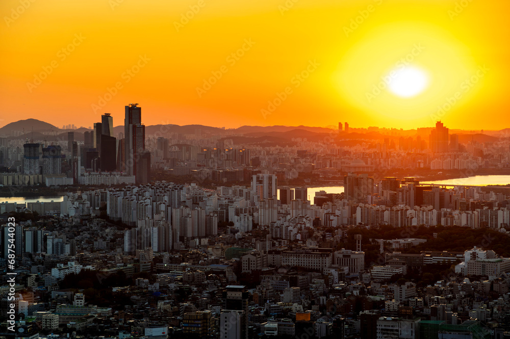 Gold sun risae or sunset of Seoul cityscapes with high rise office buildings and skyscrapers in Seoul city, Republic of Korea in winter golden yellow sky and cloud