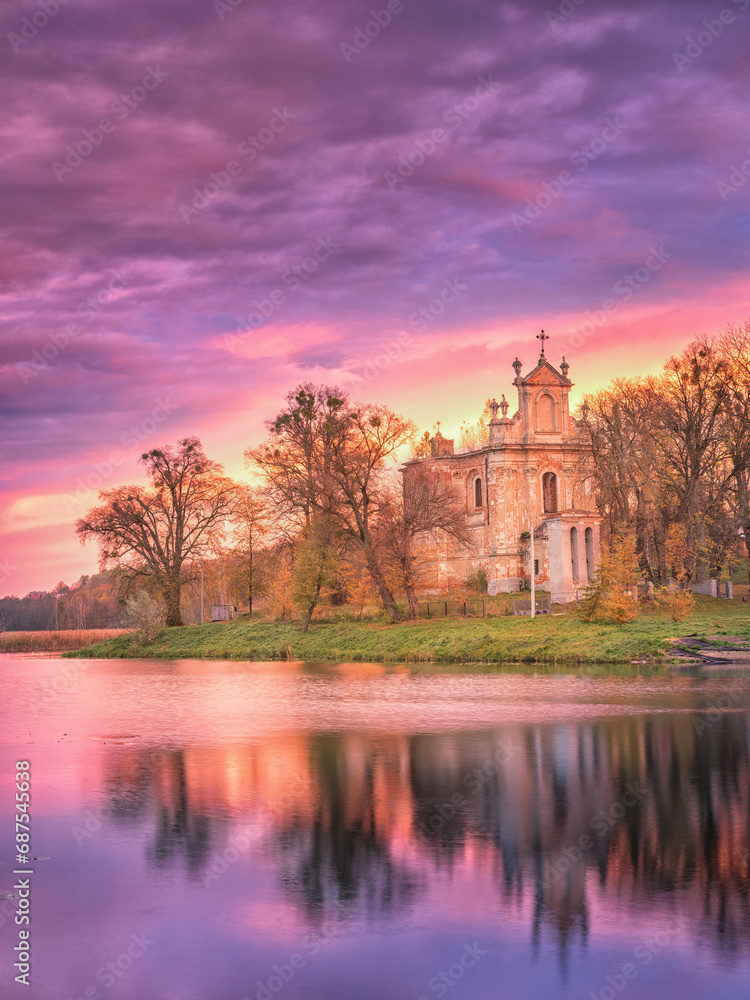 Fototapeta premium lake view to old church in violet colours of sky in sunrise