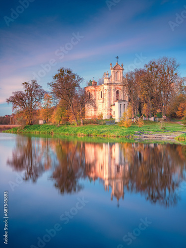 view to old cathedral through calm lake in autumn day with free space