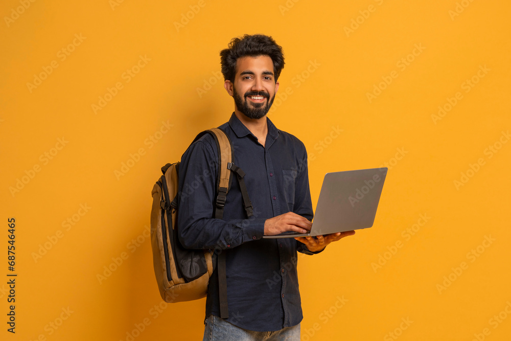 Portrait Of Young Indian Male Student With Backpack And Laptop - obrazy, fototapety, plakaty 