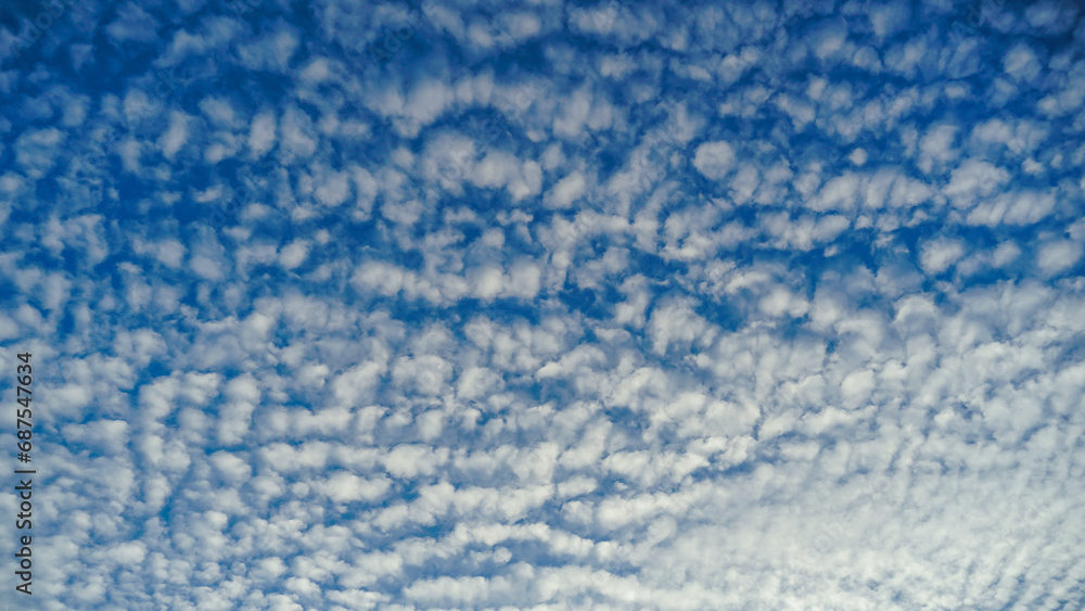 Blue sky and White cloud nature background. A daytime view of clouds and blue sky. Sparse cumulus cloud in blue sky, ground view.