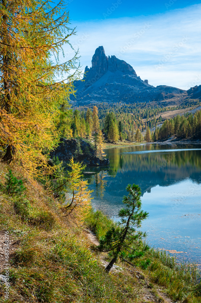 Tranquil scene of a pointed rock peak above a calm lake in the Dolomite Mountains, Italy