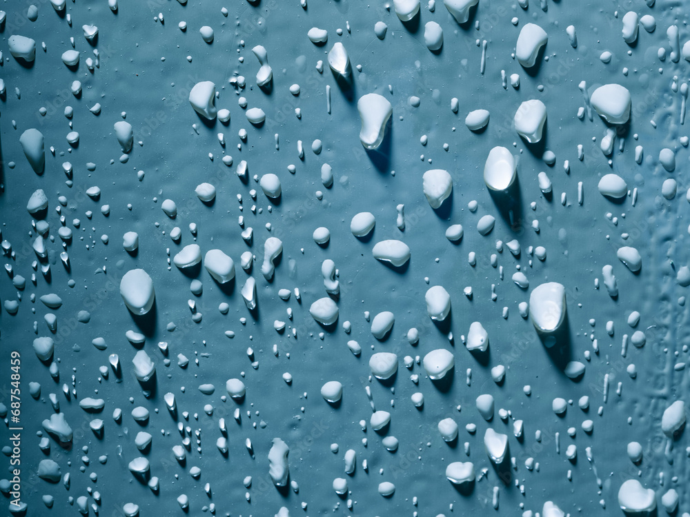 Detailled image of water droplets on a blue painted door