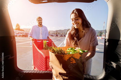 Woman unpacking groceries, man with cart photo